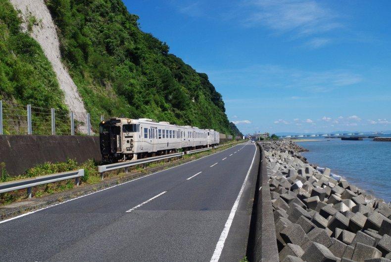 町中をぬけると雄大な桜島が登場！ やがて車窓いっぱいに青く輝く錦江湾。-0